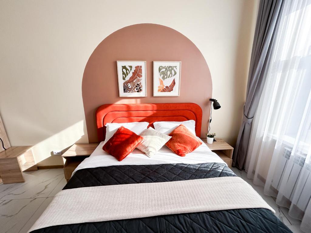 a bedroom with a large bed with red pillows at Bekarys Twins in Astana