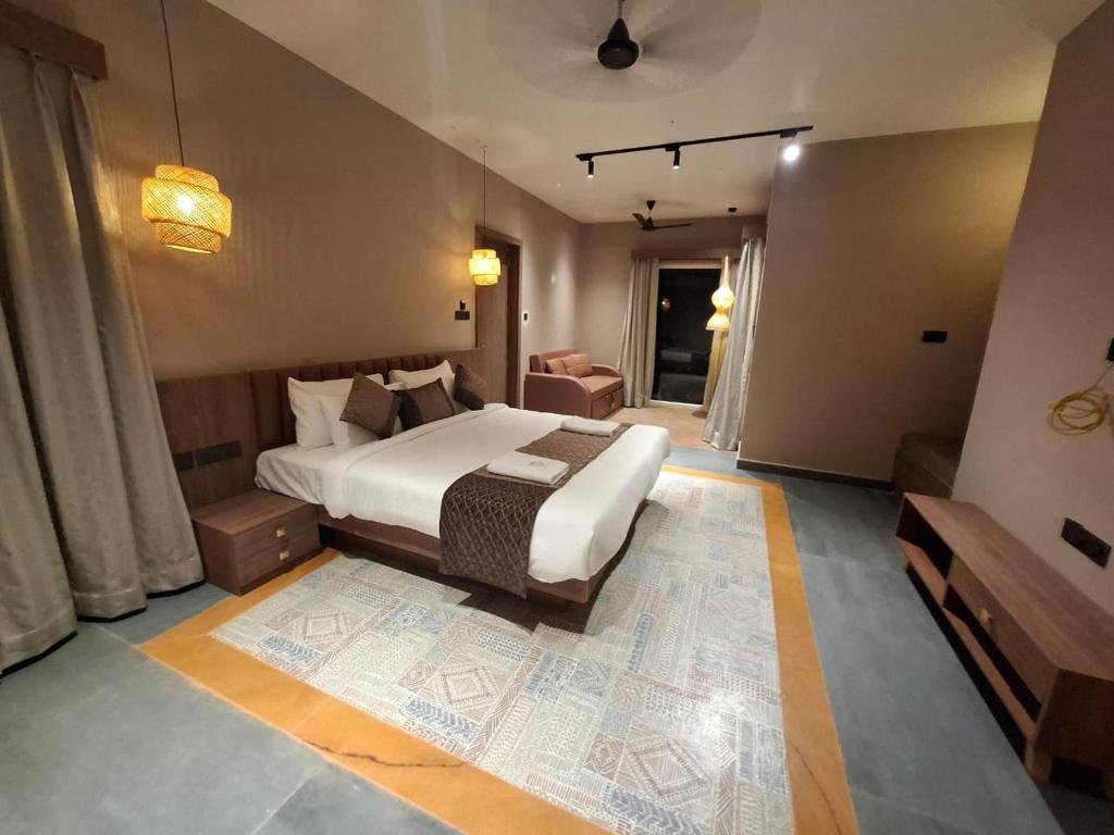 a bedroom with a bed and a room with a couch at Kayo Resort Pench in Seonī