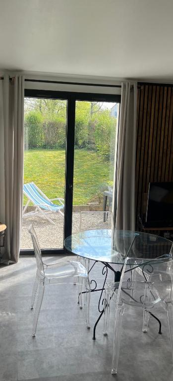 a glass table and chairs in front of a window at Appartement RDC quartier calme in Saint-Dizier