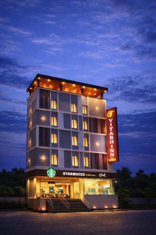 a hotel building with a sign in front of it at Vitash Inn in Tirupati