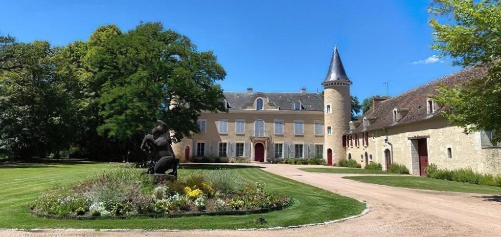 a statue in front of a building with a tower at La Brosse Estate - Chateau de la Brosse in Lureuil
