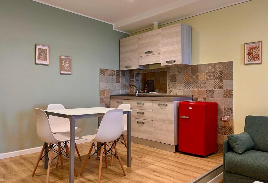 a kitchen with a table and chairs and a red refrigerator at Bixio 40, Alloggio Turistico in Montefiascone