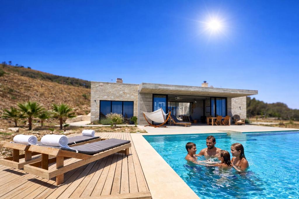 a group of people in a swimming pool with a house at Sea view villa with private swimming pool in Heraklio