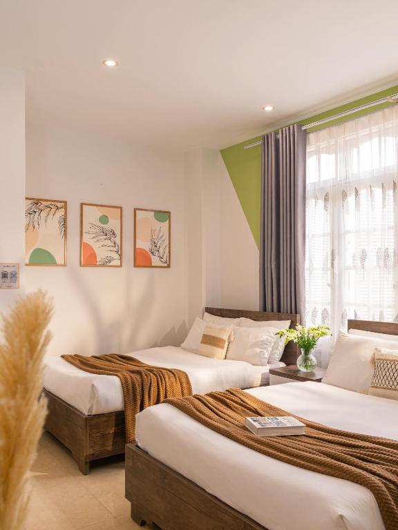 a bedroom with two beds and a window at Green Meadow Serenity - Center Hotel in Da Lat