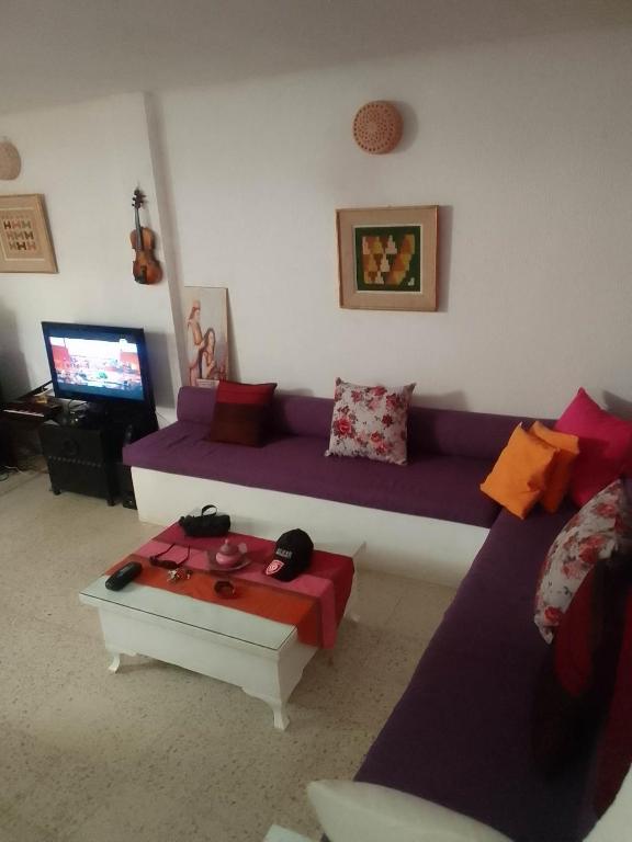 a living room with a purple couch and a coffee table at Tunisian style in La Marsa