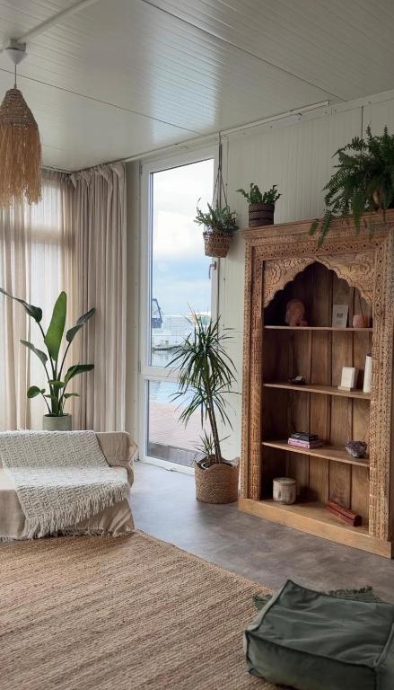 a living room with a bed and a large window at RetreatBoat Bali in Lithoijen