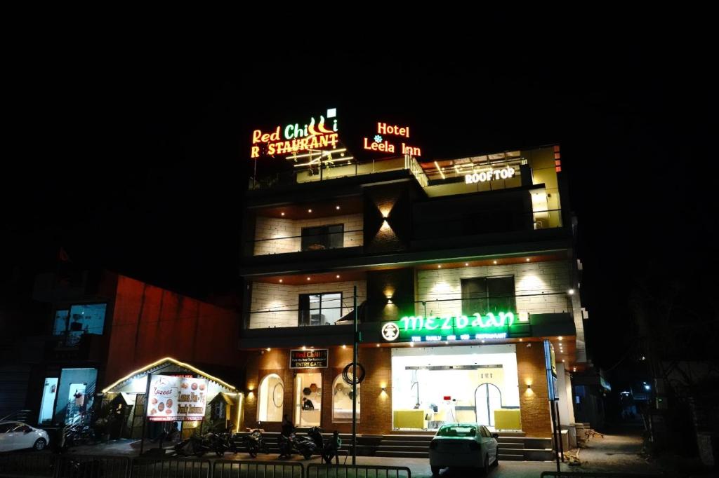 a building with neon signs on top of it at night at Hotel Leena Inn in Jhālāwār