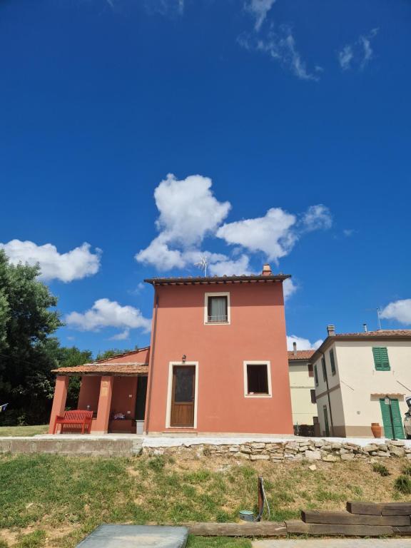 a pink house with a blue sky in the background at Casa Lori in Fauglia