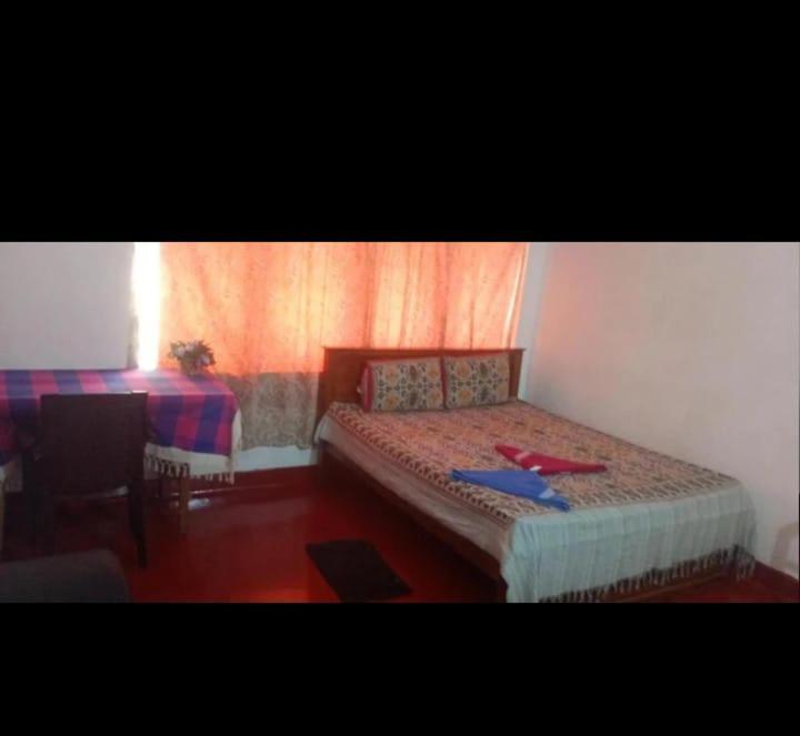 ein Schlafzimmer mit einem Bett, auf dem ein roter Gegenstand liegt in der Unterkunft Hotel refresh in Moratuwa
