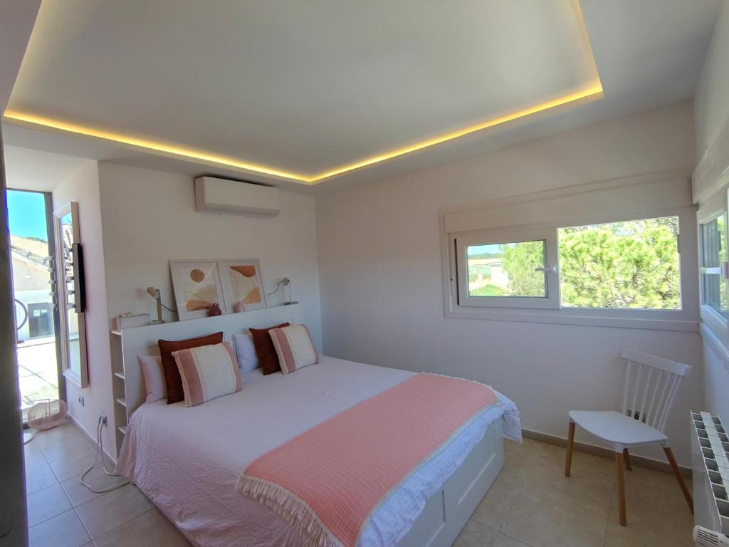 a white bedroom with a bed and a window at El Torreón del Palacio in Boadilla del Monte