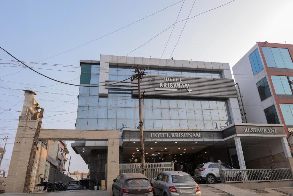 a building with cars parked in front of it at Hotel Krishnam Vrindavan in Vrindāvan