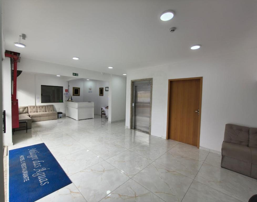 a large room with a lobby with a couch and a table at Hotel Milagre Das Águas in Aparecida