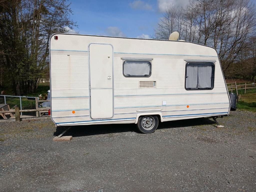 a white trailer parked in a parking lot at Caravane in Beaufay