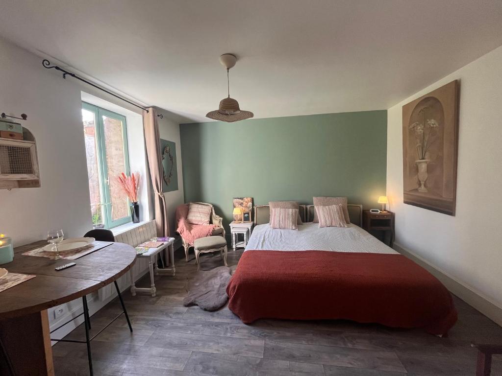 a bedroom with a bed and a table in it at La mésAnges in Giverny