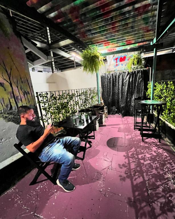 a man sitting in a chair at a table at Varandas Av Paulista in São Paulo