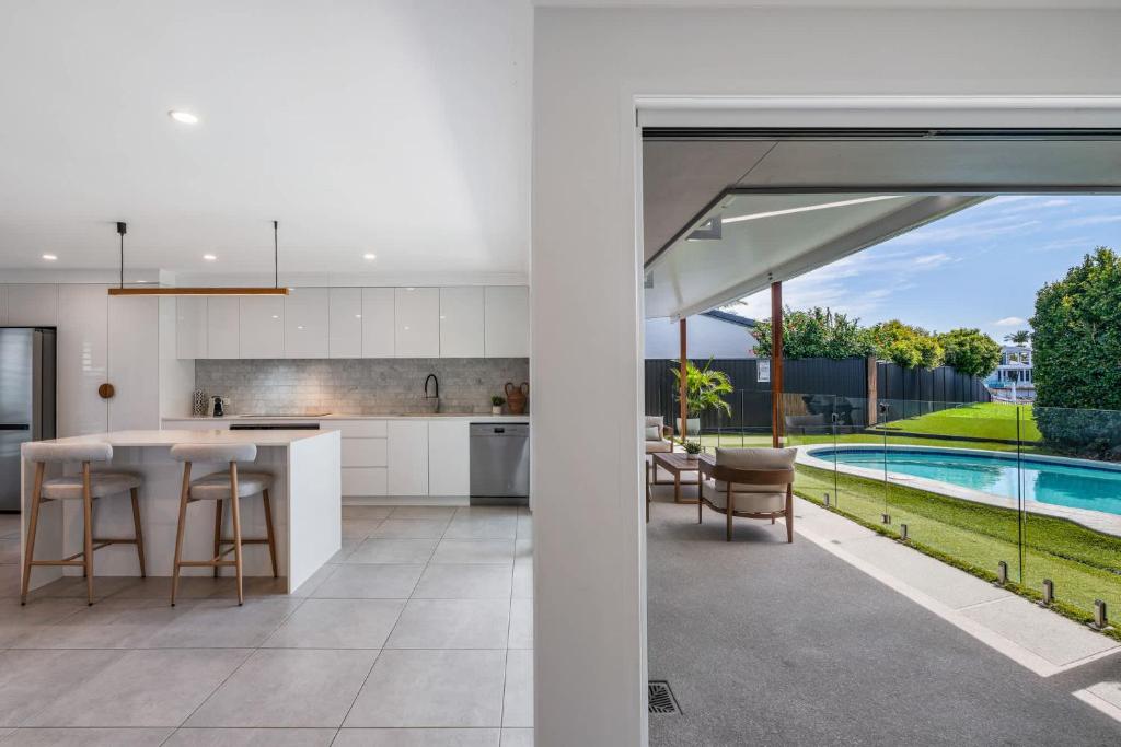 an open kitchen and dining area with a pool at Mooloolaba Canal Retreat with Pool Sleeps 12 in Mooloolaba