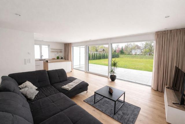 a living room with a couch and a large window at Moderne Wohnung am Flussufer in Herford