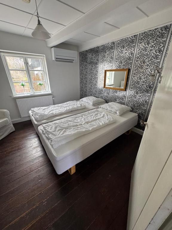 a bedroom with two beds and a mirror on the wall at Skelby Præstegård lej 2 in Gedser