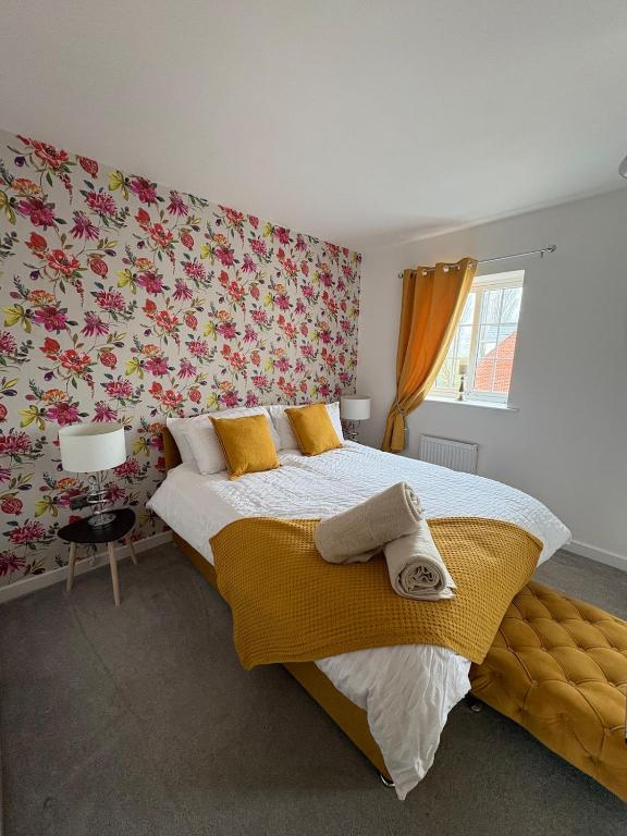a bedroom with a large bed with floral wallpaper at Whistle Stop Terrace in Barnby Dun