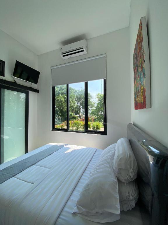 a bedroom with a large bed and a window at Kampung Febri Resort in Cibuntu