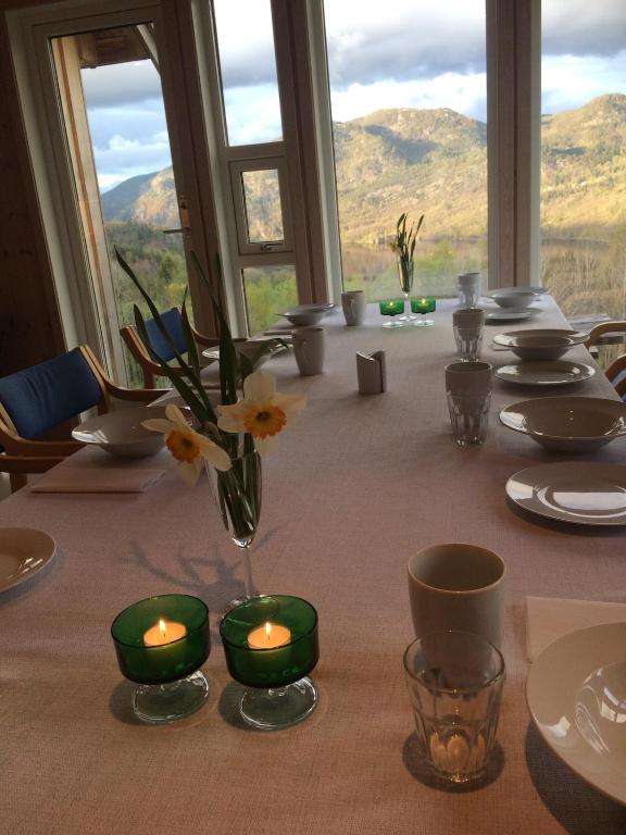 a table with candles and flowers in a room with mountains at Konstali Gard in Flekkefjord