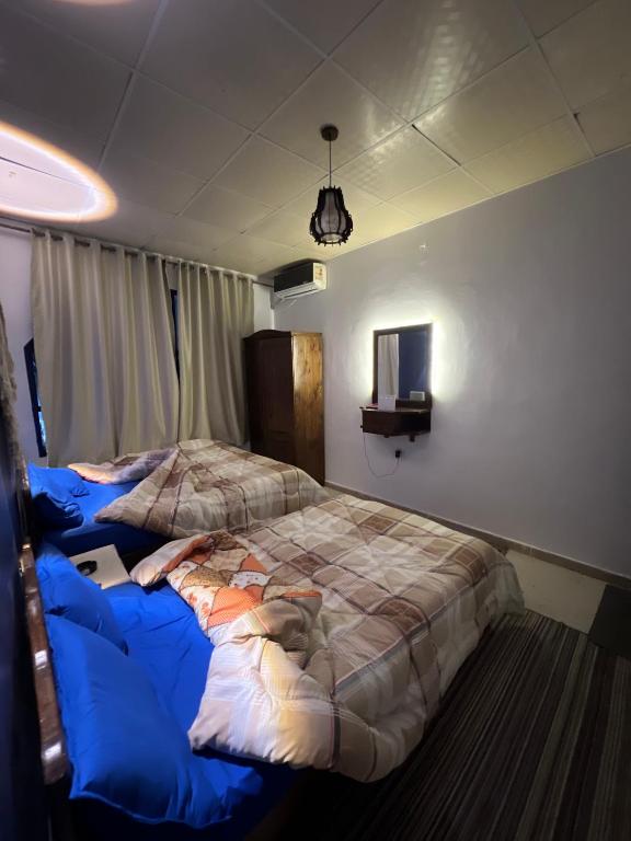 a bedroom with two beds with blue sheets at Cabana House in Dahab
