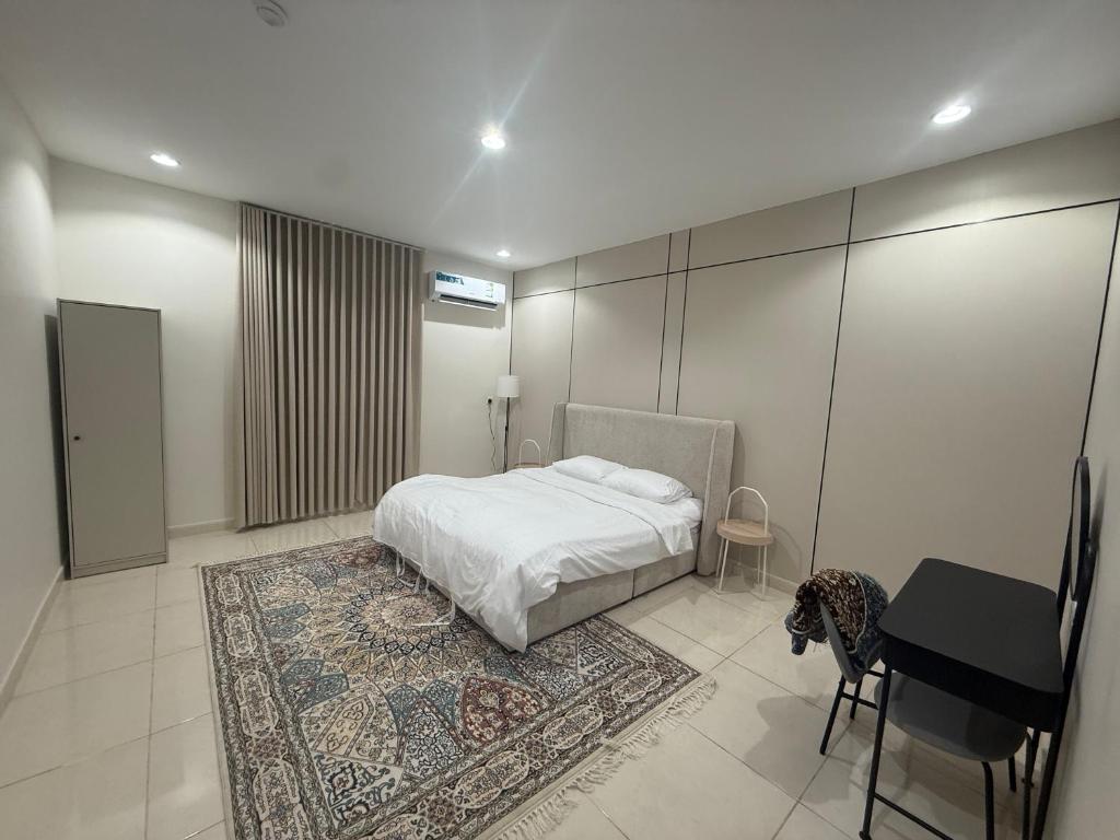 a bedroom with a bed and a table and a rug at أستديو كلاود السحاب in Al Baha