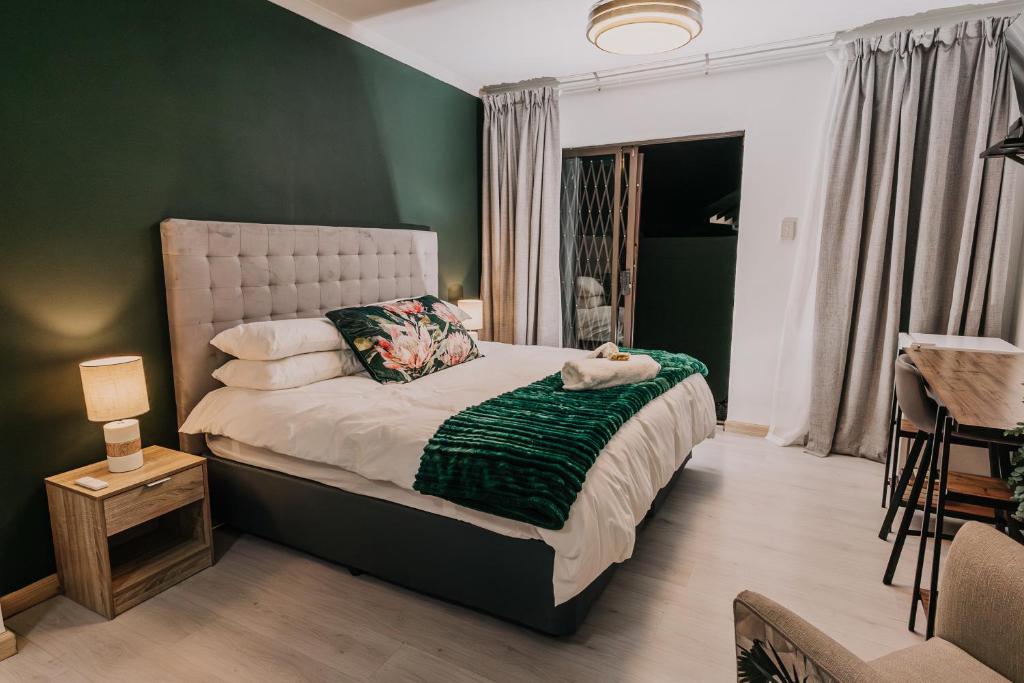 a bedroom with a bed with a green wall at Seek First B&B in Pretoria