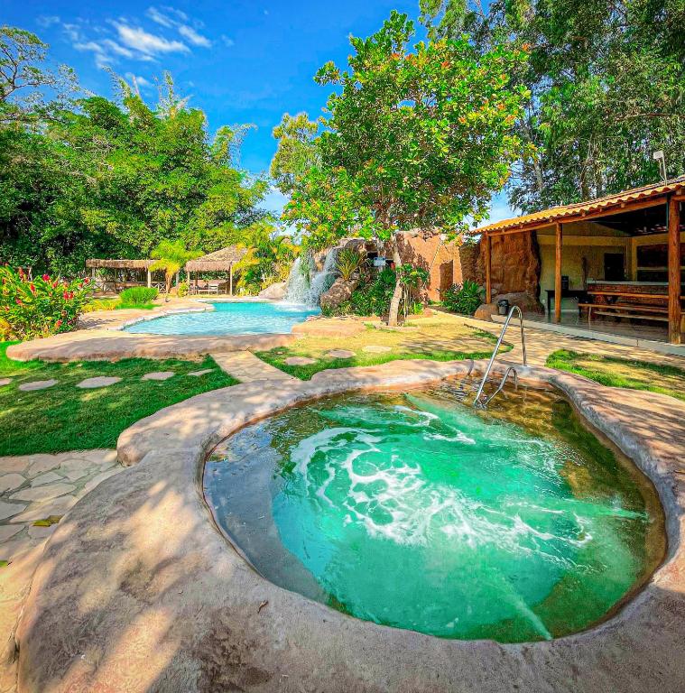 a hot tub in a backyard with a waterfall at Pousada Grande Rio in Pirapora