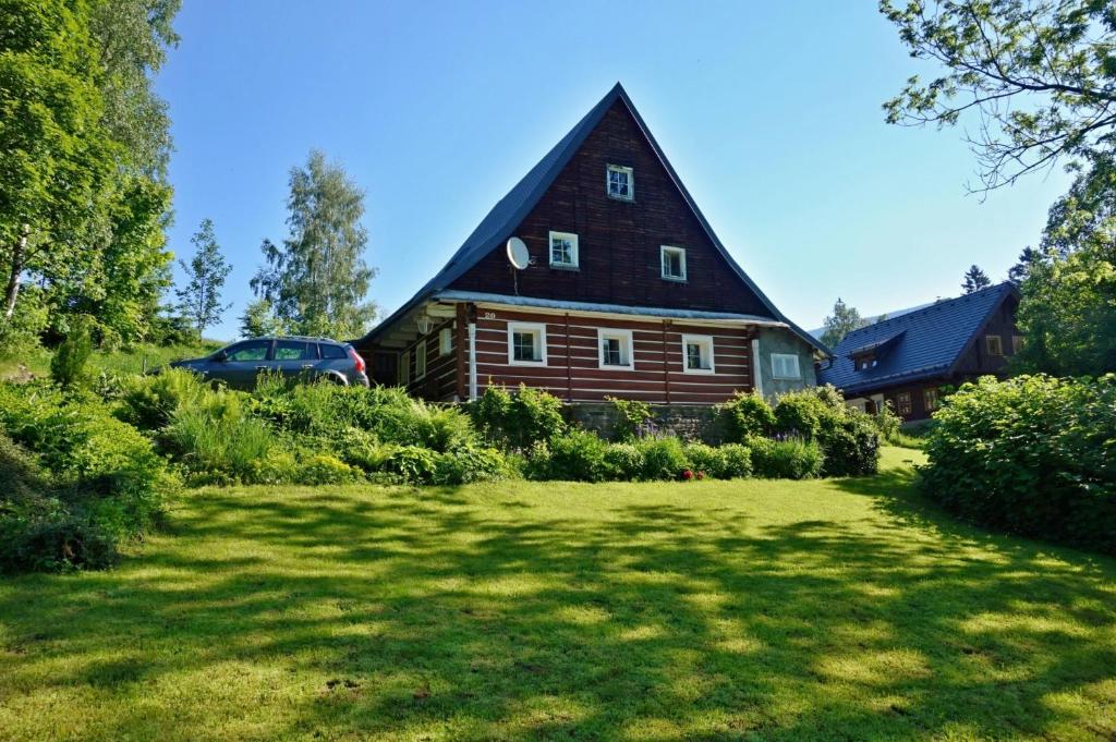 a large wooden house with a grass yard at Chalupa Horní Morava in Dolní Morava
