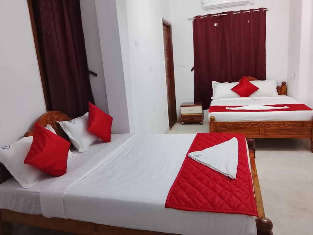 two beds with red and white pillows in a room at HoTEL K7 in Chennai