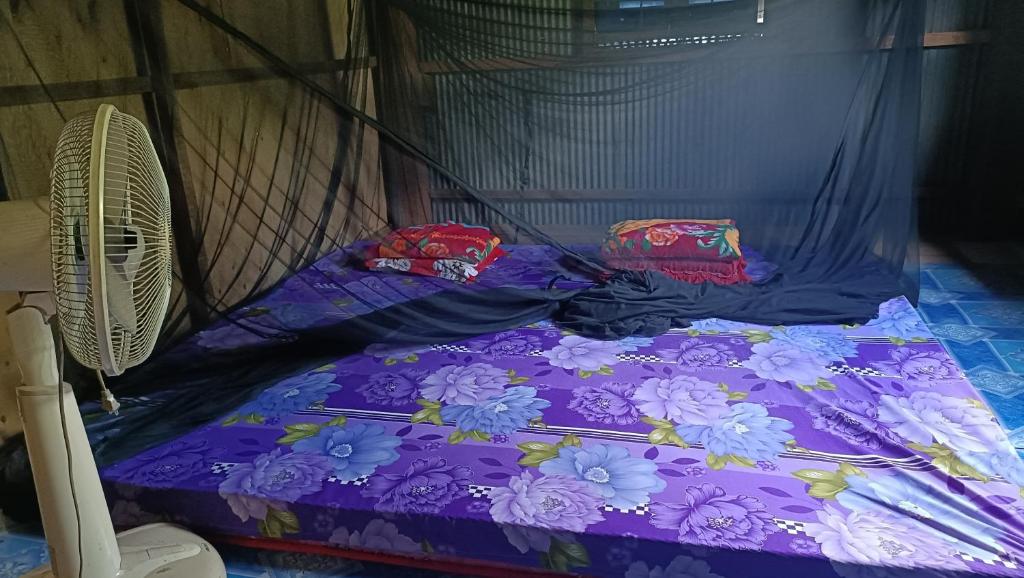 a bed in a room with purple sheets and pillows at Homestay in Kampong Cham in Kampong Cham