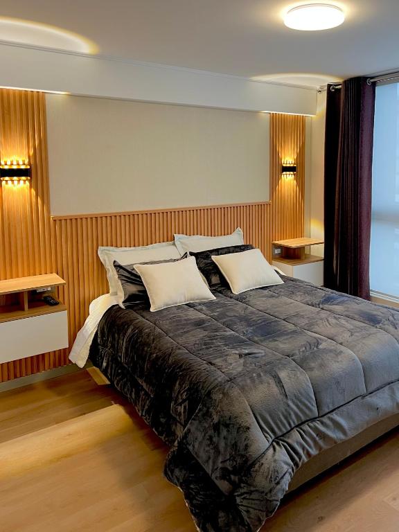 a bedroom with a large bed with two pillows at Condo Apartment Suite Misti Volcano View in Arequipa