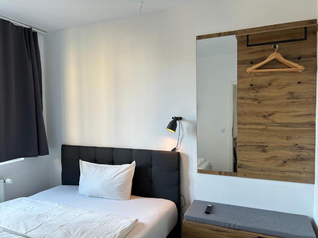 a bedroom with a bed and a wooden wall at Noble Rooms Saarbrücken in Saarbrücken