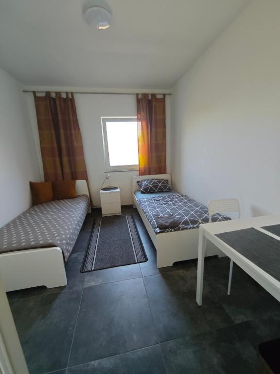 a room with two beds and a table at Zimmervermietung-Nbg in Nuremberg