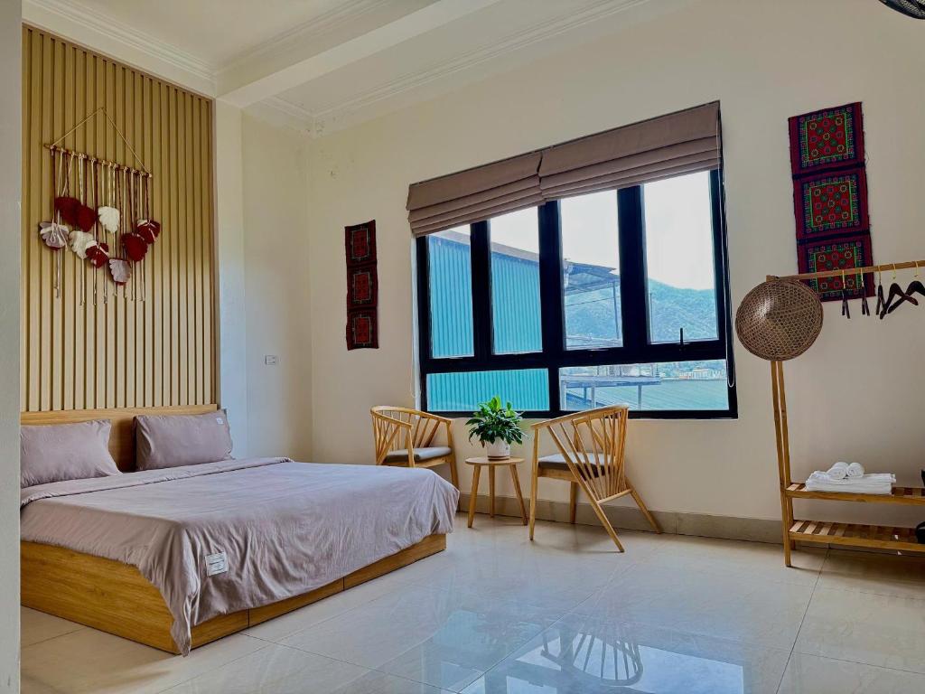 a bedroom with a bed and a table and chairs at Pá Homestay - Thành phố Cao Bằng in Cao Bằng