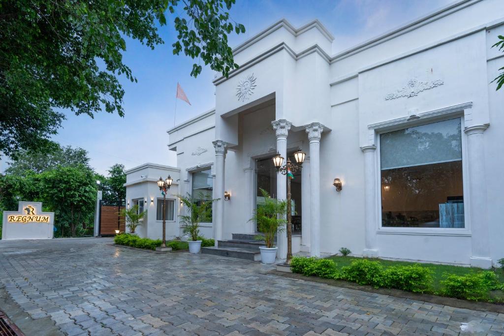a white facade of a building at Corbett The Regnum Resort in Rāmnagar