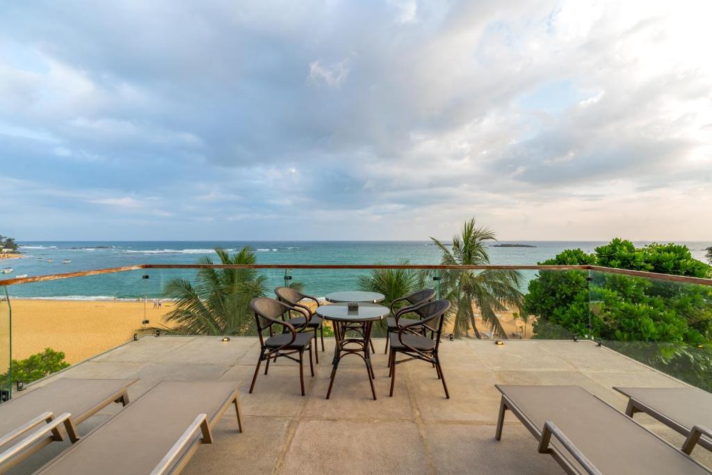 a balcony with a table and chairs and the ocean at Casa Tartaruga in Unawatuna