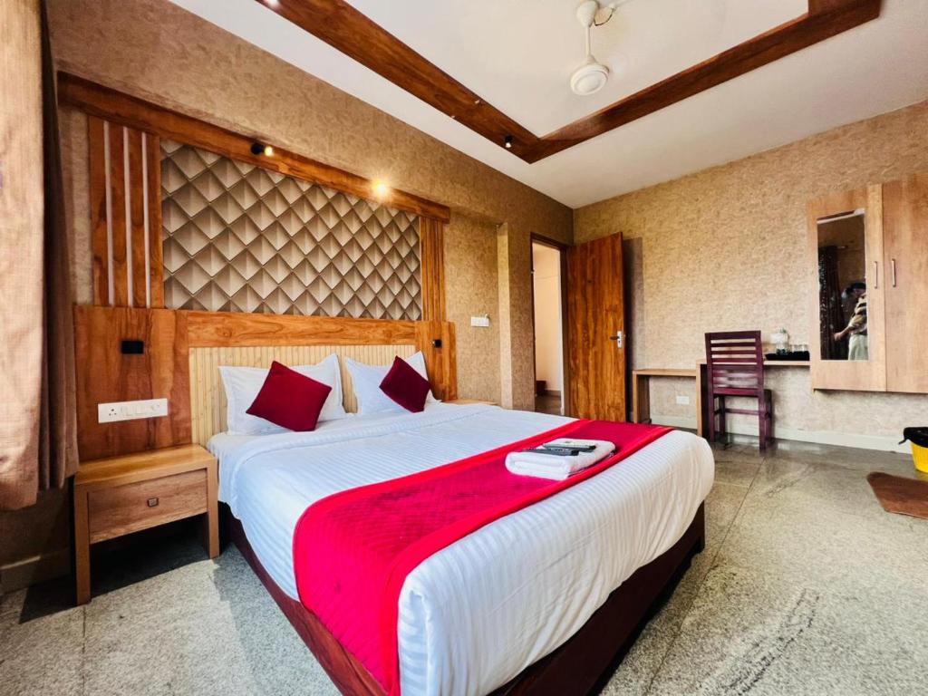 a bedroom with a large bed with a red blanket at Celestial Heights Kakkanad in Cochin
