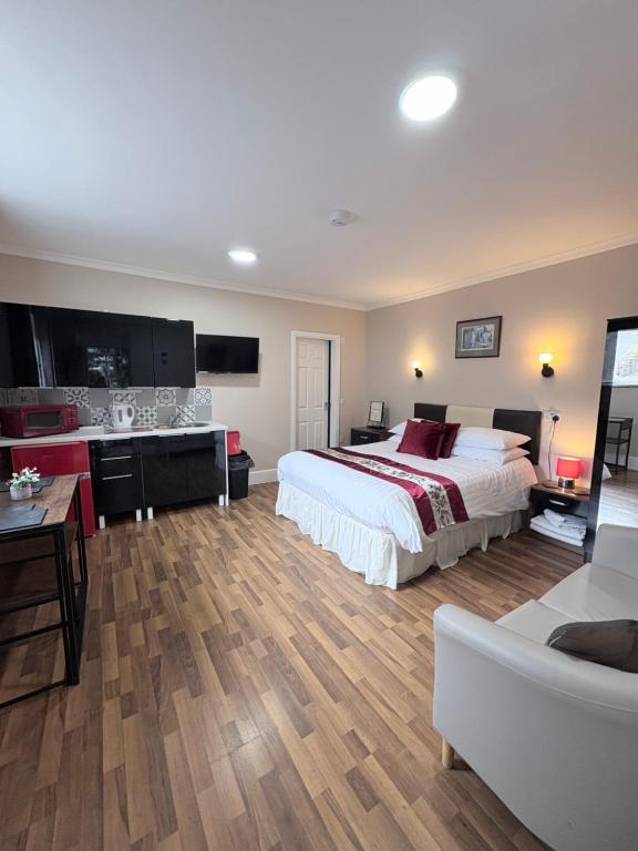 a bedroom with a large bed and a living room at Windermere Studio Rooms - Free Onsite Parking in Windermere