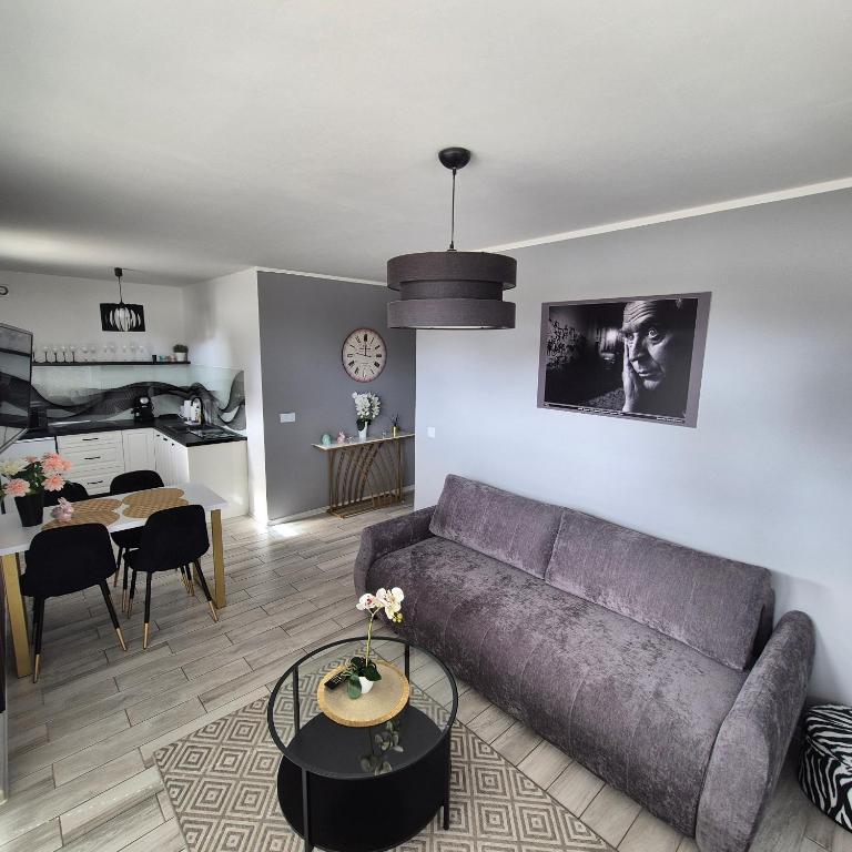 a living room with a couch and a dining room at Apartament Cinema in Mielno