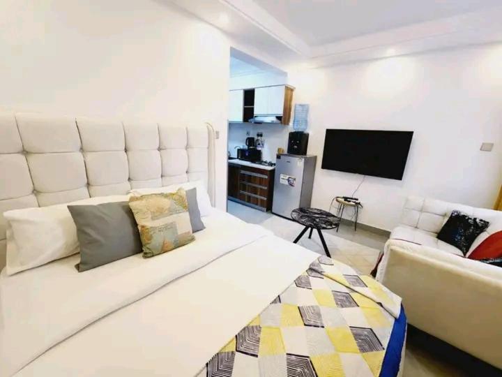 a living room with a white couch and a flat screen tv at Lanson in Nairobi