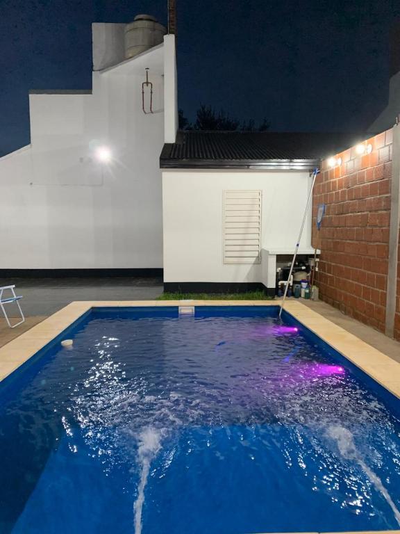 a swimming pool at night with purple lights at Dario Claussen house in Garupá