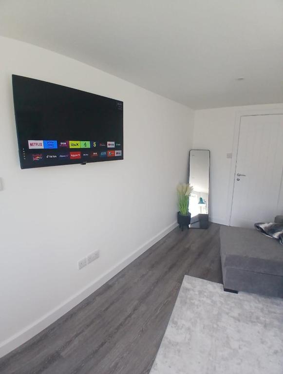 a living room with a couch and a flat screen tv at Moodyscroft Homestay, NEC, BHX, Resorts world, HS2, JLR - Netflix in Birmingham