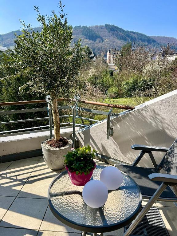 a glass table on a balcony with a tree at Molive in Traben-Trarbach