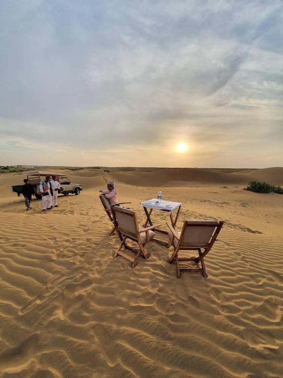 a table and chairs in the sand in the desert at Royal Salma Resort A family Luxury Camp 