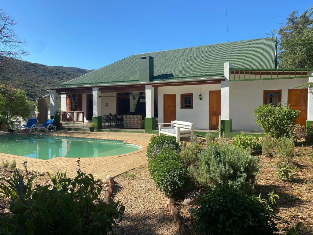 a house with a swimming pool in front of it at Emma's Place in De Rust