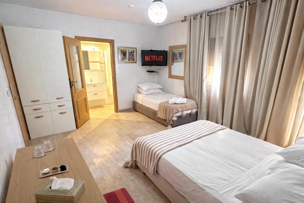 a hotel room with two beds and a table at Bab louka in Aït Bou Zguia