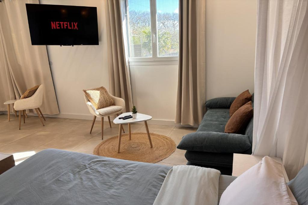a living room with a bed and a couch at Le cocon près d'Albi in Saint-Grégoire