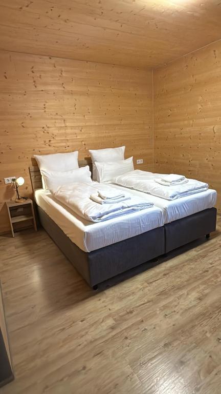 a large bed in a room with a wooden wall at URBAN OAK Smart Stay in Cologne